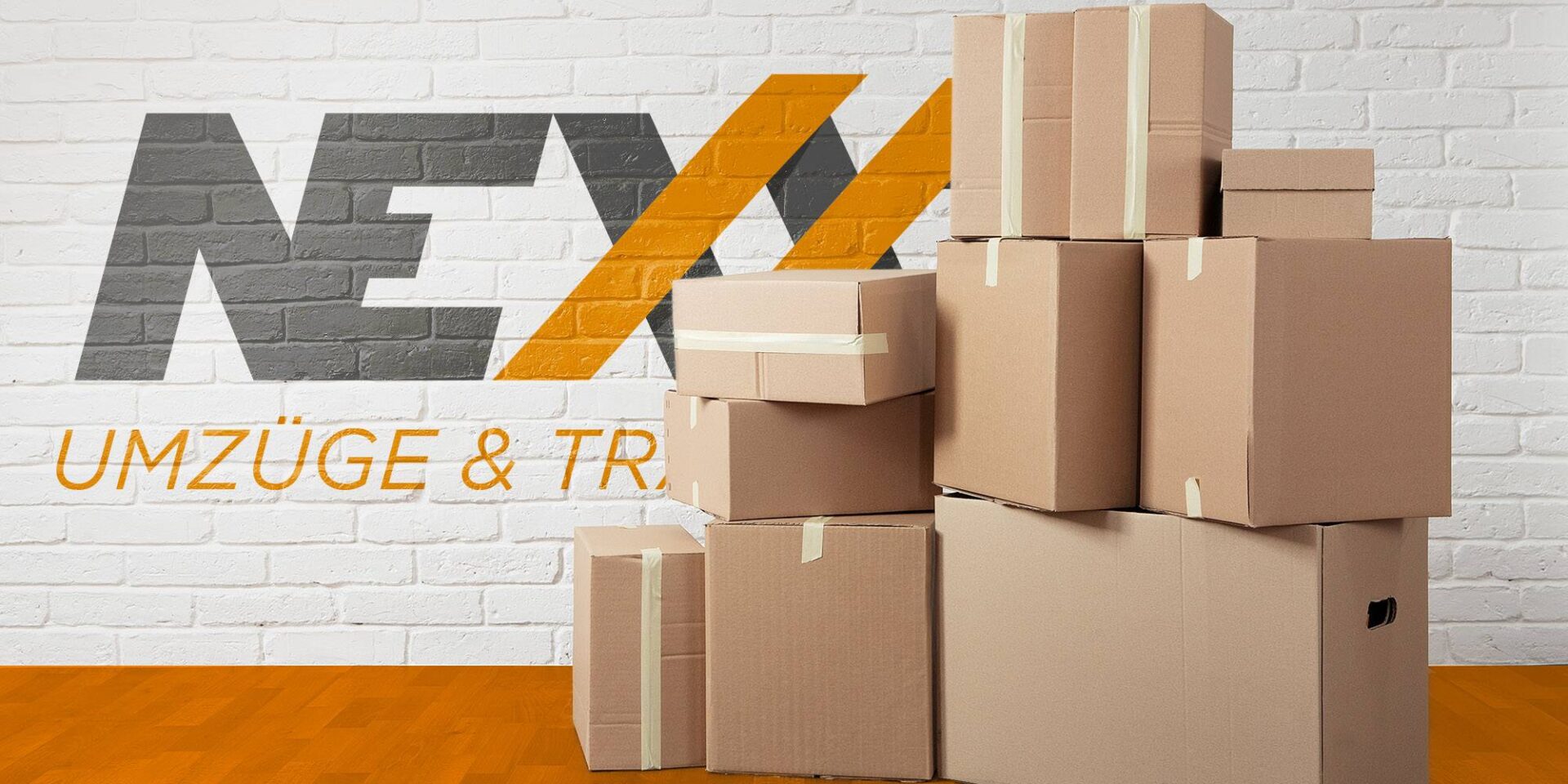 Ein Stapel Umzugskartons von einem Umzug vor einer Steinwand mit dem Logo der Firma Nexxt Umzüge und Transporte